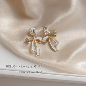 Holiday crystal earrings with white enamel bows.